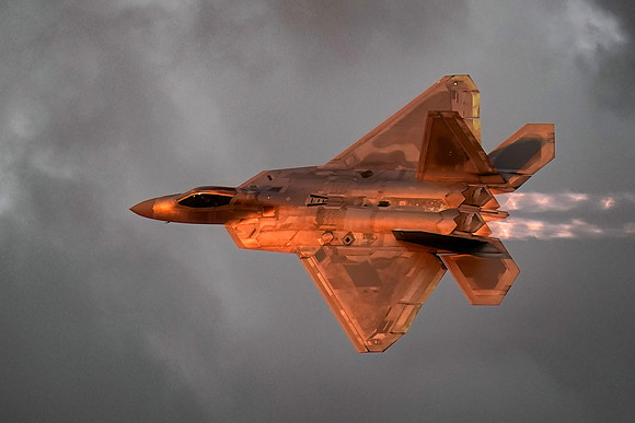 An F22 jet makes high speed passes in front of the air show crow