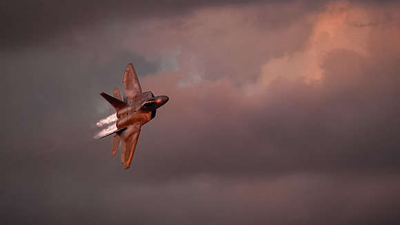 An F22 jet makes high speed passes in front of the air show crow